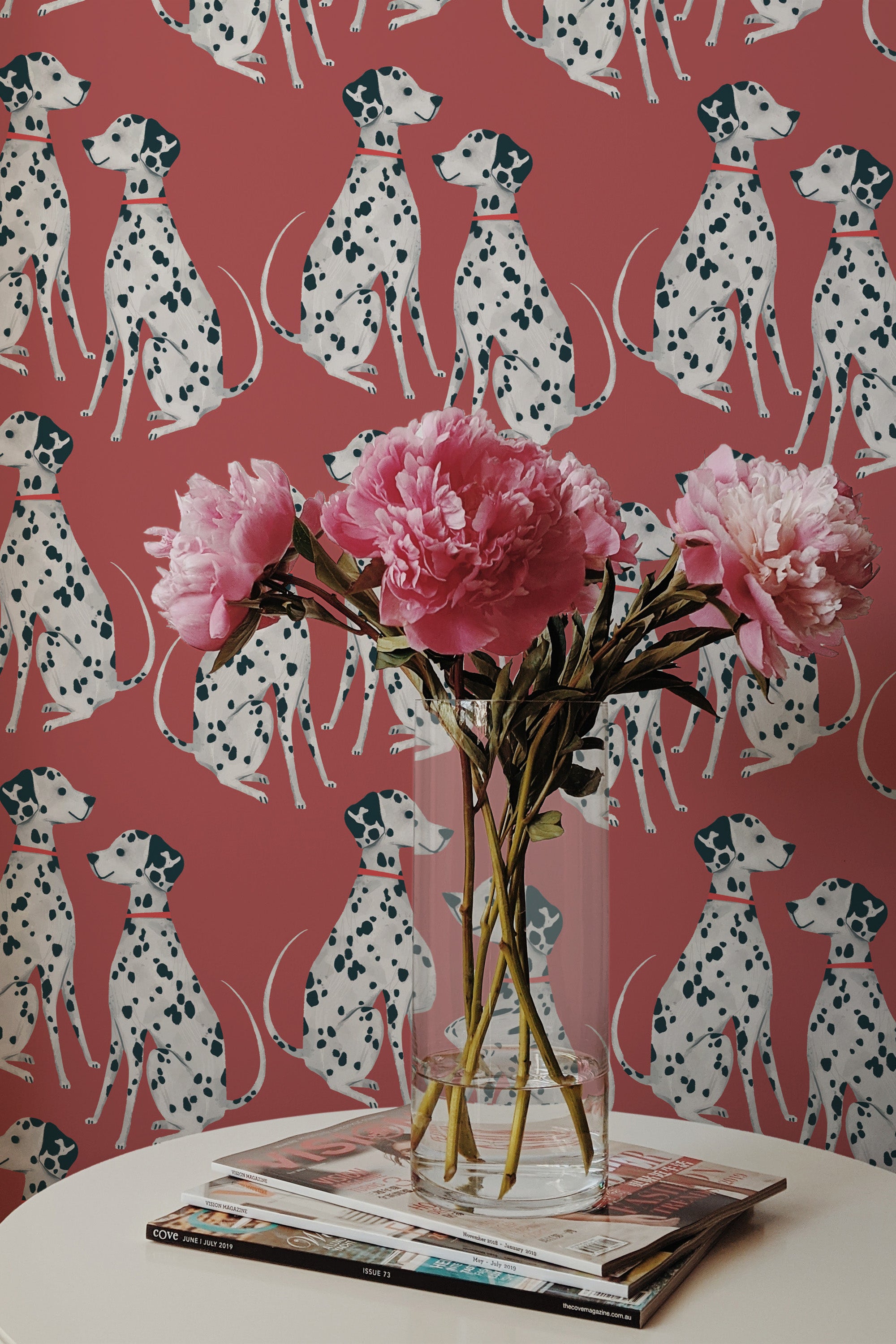 Self-adhesive burgundy wallpaper with a pattern of white dalmatian dogs and black spots, complemented by a vase of pink peonies on a table.